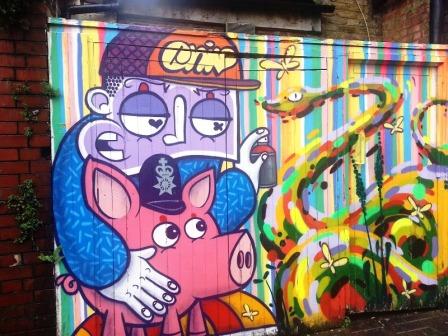 A pig wearing a policeman's helmet that is painted on a wall of Brick Lane in East London.