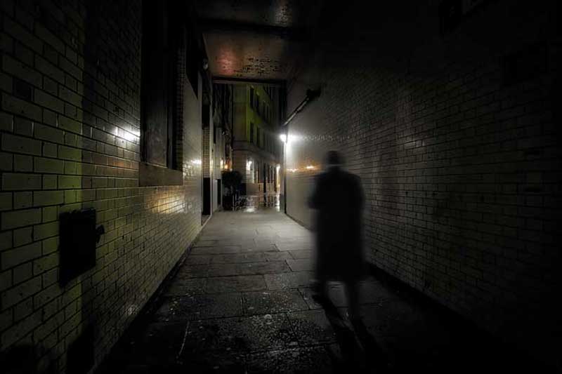 A ghostly figure in an allleyway.